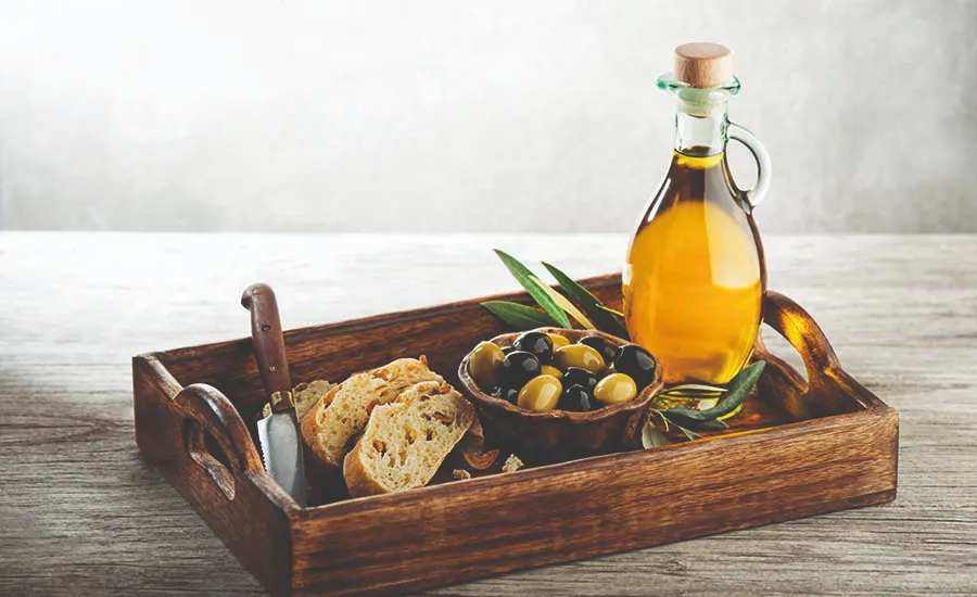 Olivenolje, hel oliven og surdeigsbrød på fat