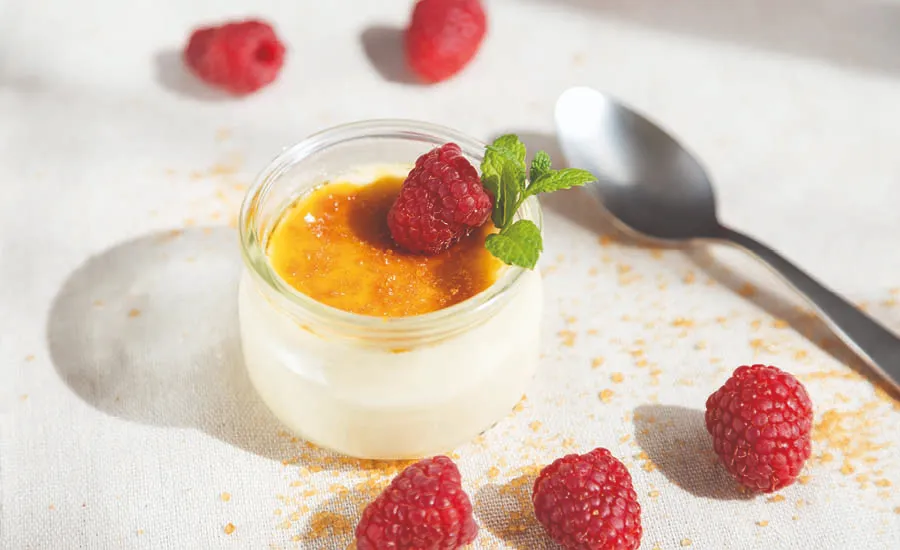 Deilig økologisk dessert med økologiske bringebær liggende ved siden av